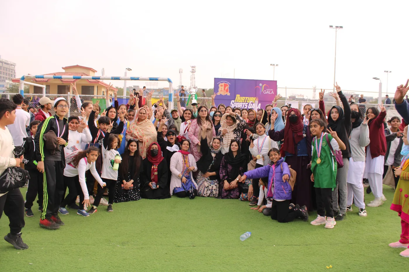A large school community group gathered during an outdoor event